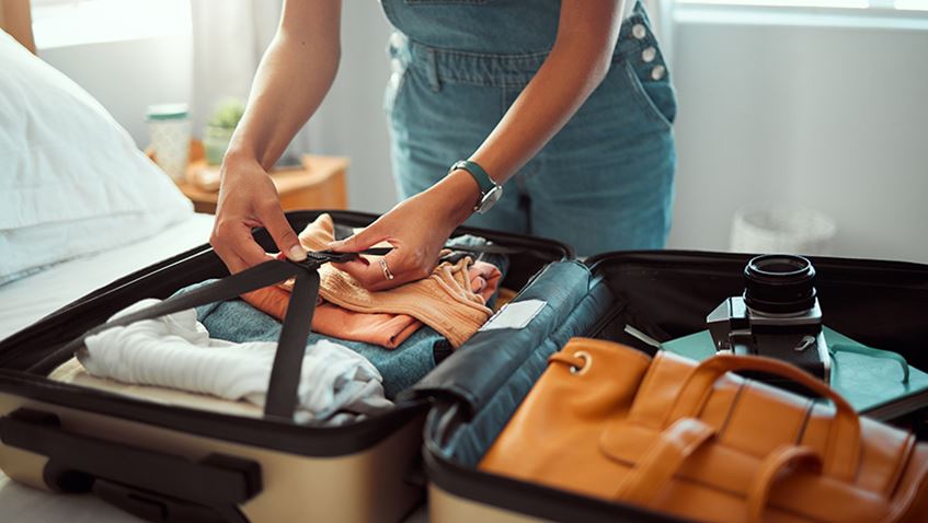 A person packing a suitcase