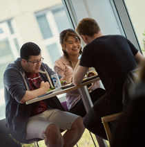 Students sat around a table and laughing