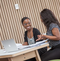 Students sat down in front of a laptop and working together