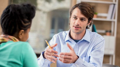 Two people talking at a table 