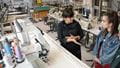 Student and teacher with sewing facilities in background