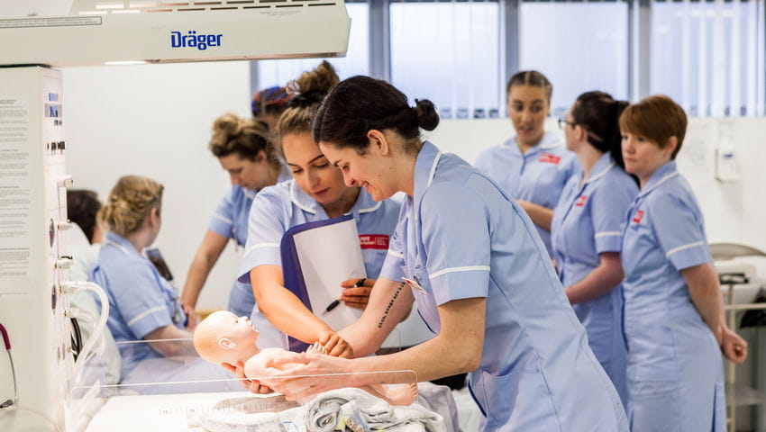 Midwifery students with a dummy in the Skills Simulation Suite on Glenside Campus.