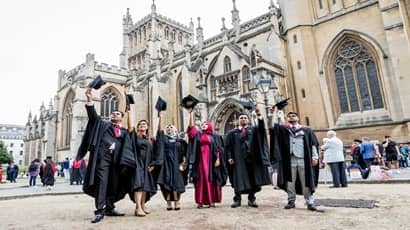 Group of student standing outside of graduation ceremony.