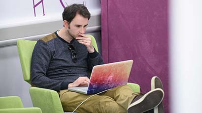Student using a laptop in the library