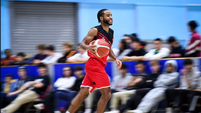 UWE Jets basketball player casually dribbling across court. 