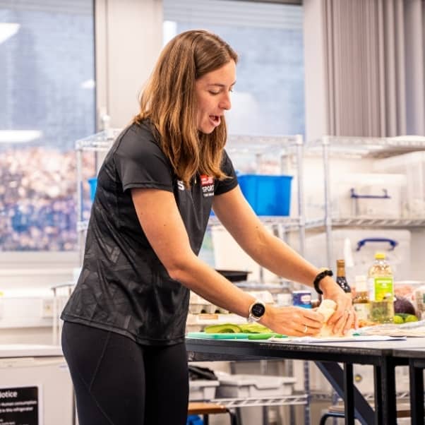 A woman folding a wrap while demonstrating in a class