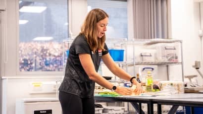 A woman folding a wrap while demonstrating in a class
