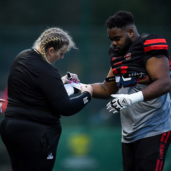 UWE Performance Sport sport therapist Emily wrapping an American Football player's glove.
