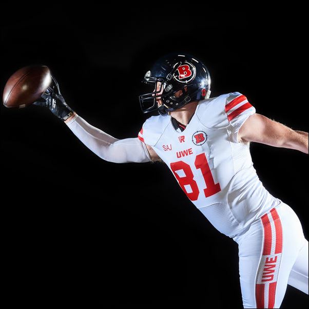 American Footballer student-athlete lunging for a ball.
