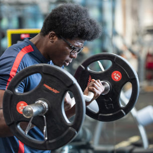 Close up of people's hands using gym equipment.