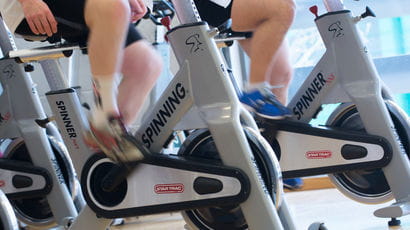 Close up of people using exercise bikes.