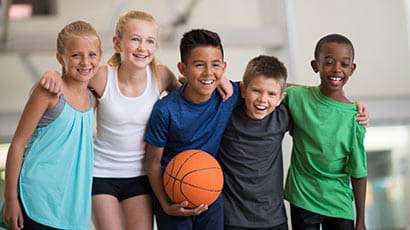 Children posing with a basketball.