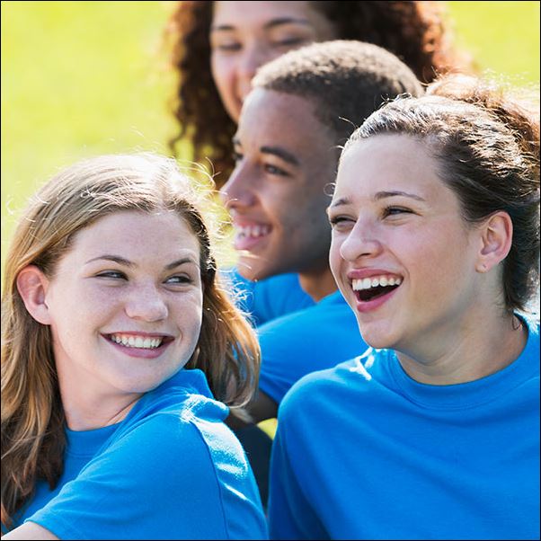 Teenagers wearing blue on the grass.