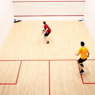 Two people using a squash court at Frenchay Campus.