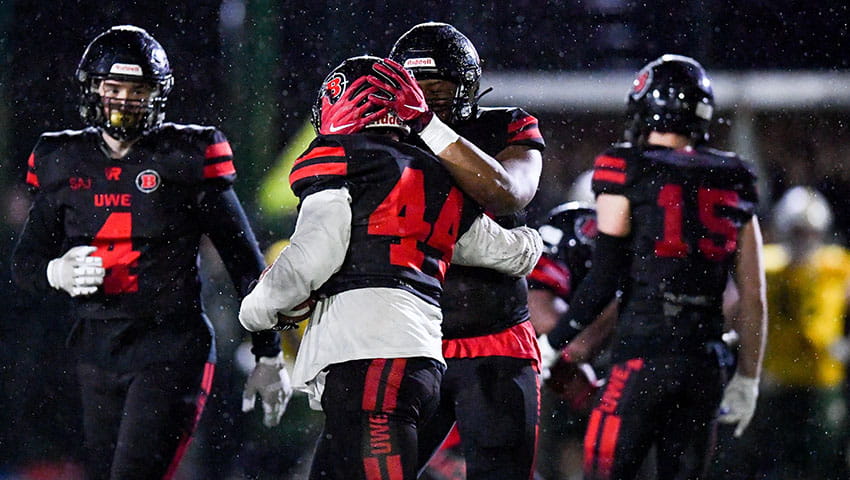 UWE Bullets player congratulating a team mate with a pat on their football helmet.