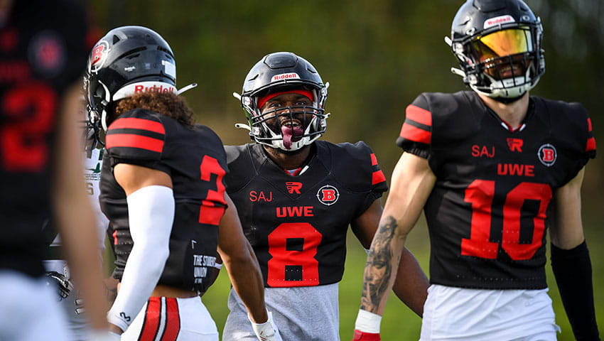 Three UWE Bullets players walking about the football pitch.