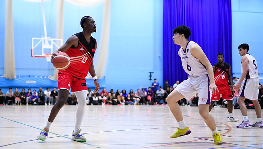 UWE Jets basketball player pausing in front of an opponent on the court. 