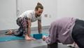 An instructor demonstrates a low lunge during a MOVE yoga class. 