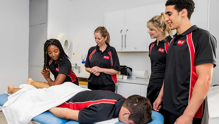 Sport Rehabilitation students practising treatments on patient lying on treatment table