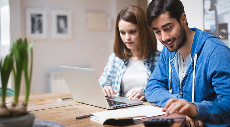 Two people working on a laptop