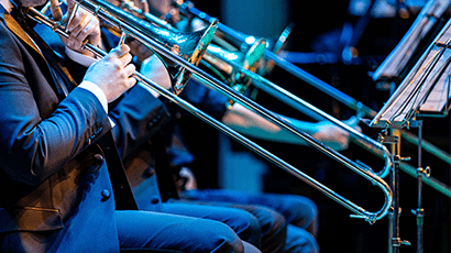 Three seated trombone players