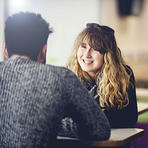 Two people talking at a table in Onezone on Frenchay Campus