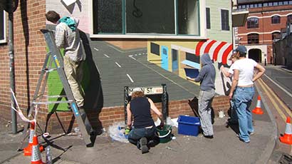 Volunteers painting a community mural.