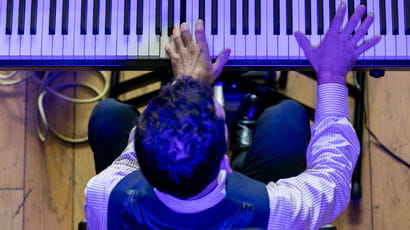 Person playing electric piano during a performance.