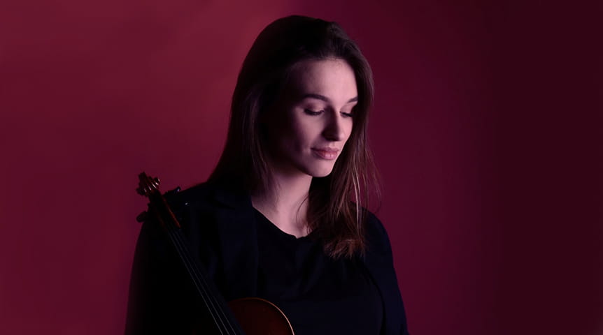 Young woman against red background holding a violin