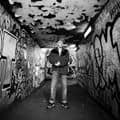 James Tombling short in black and white in front of graffitti.