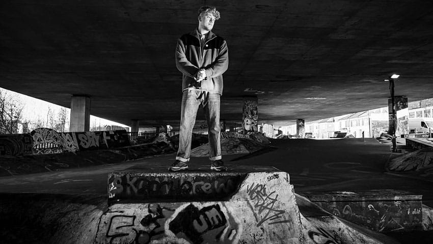 James Tombling short in black and white standing on a platform in and underpass.