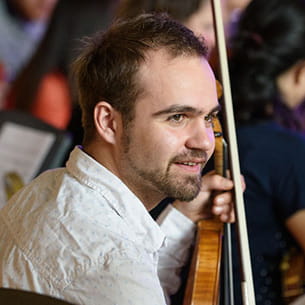 Person holding a violin during a performance.