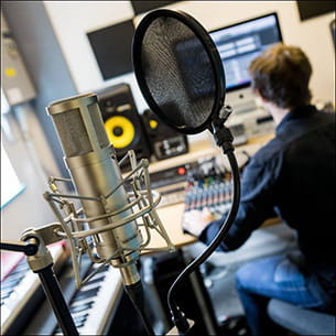 Person using a computer in a recording studio.