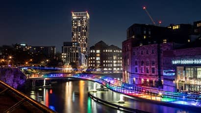 Bristol harbour at night with led lights shining on the bridge.