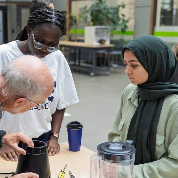 Student and staff volunteers fixing a blender at the repair café.