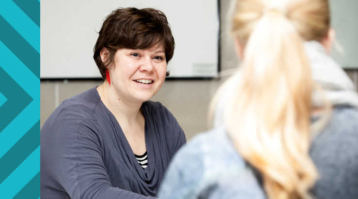 A postgraduate student talking to a staff member about funding support