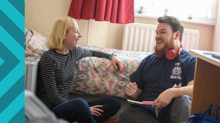 Two students laughing together in accommodation