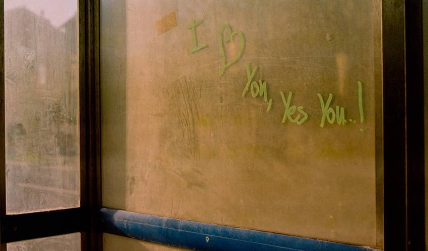 Graffiti on a bus stop says 'I love you, yes you!'