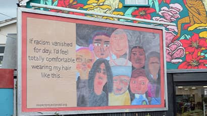 A billboard in St Werbughs in Bristol shows children's illustrations and the words if racism vanished for day I'd wear my hair like this