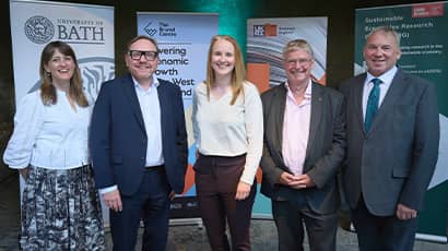 Five people stand together looking at the camera