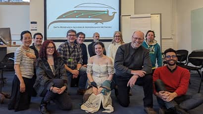 A group of people sitting on the floor in a classroom setting