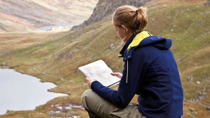 Student reading by a lake