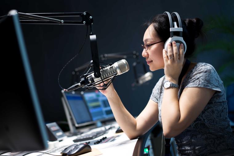  Female radio presenter at Sound Women South West, recording live radio show.