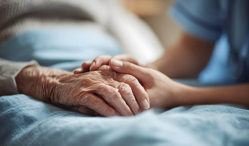 Image showing the hands of a care giver holding the hand of an eldery patient