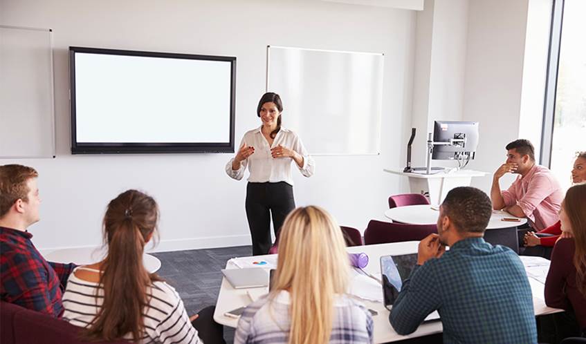 Woman lecturing students in a classroom. C: Monkey Business Adobe.