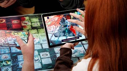 Woman playing an augmented reality board game using a tablet computer