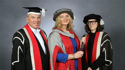 Professor Steve West, Katherine Bennett CBE and Professor Elena Marco in graduation gowns.