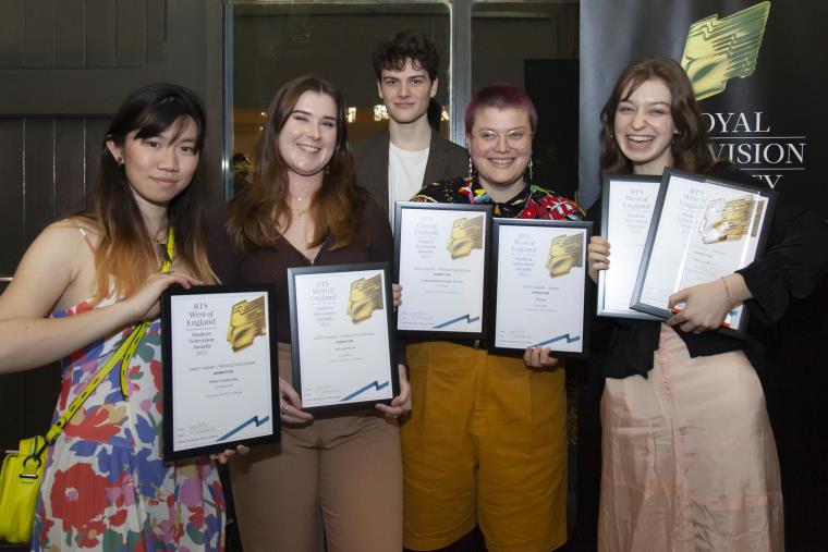 Group of students holding their RTS award certificates to camera