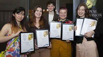 Group of students holding their RTS award certificates to camera