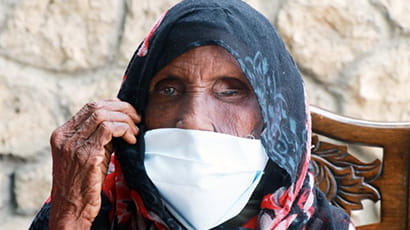 A photo of an older Somali woman wearing a mask over the lower half of her face